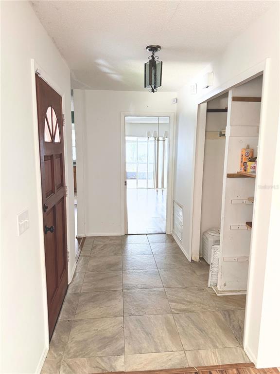 An entryway features tile flooring, a wooden front door, and an open closet — 623 SWALLOW DRIVE, CASSELBERRY, FL