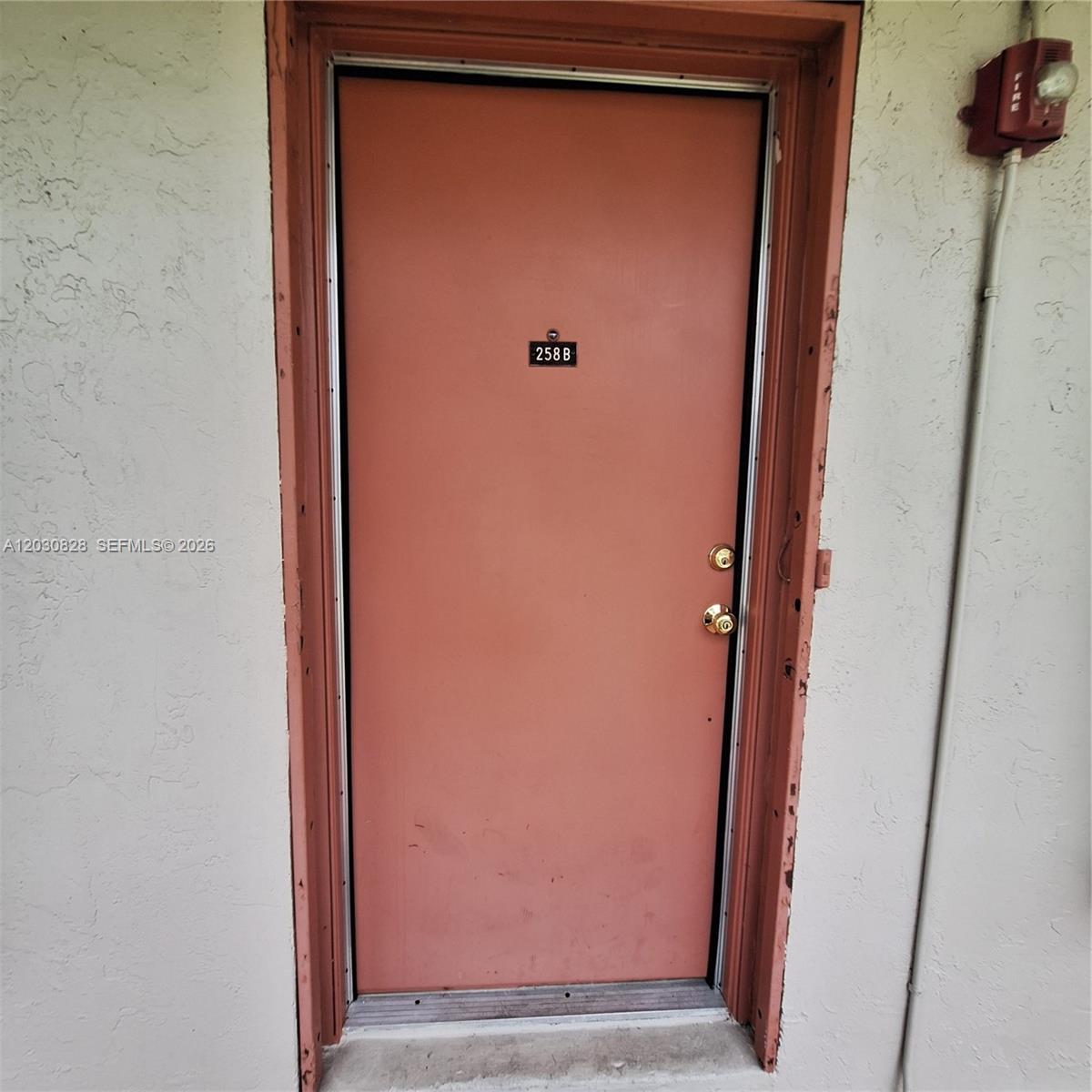 A salmon-colored exterior door labeled 258B is set within a textured beige wall — 12850 SW 43rd Dr # B, Miami FL 33175, MIAMI, FL