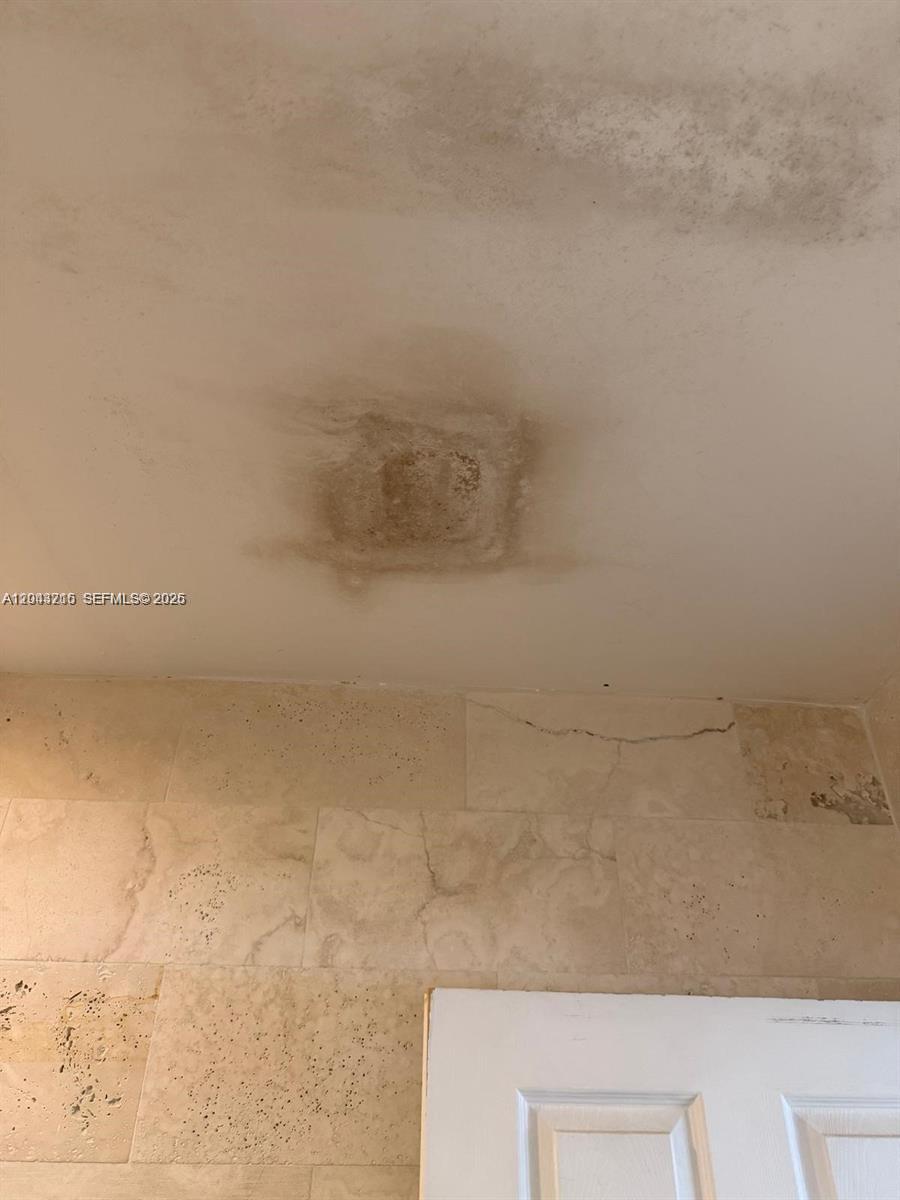 A bathroom ceiling shows a large water stain and a crack in the wall tile — 5600 SW 74th Ct, Miami FL 33143, MIAMI, FL