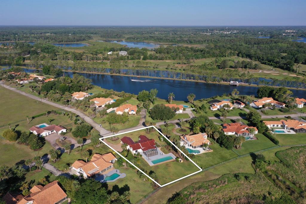An aerial view shows a house with a red roof, pool, and patio in Florida — 13300 SKIING PARADISE BOULEVARD, CLERMONT, FL