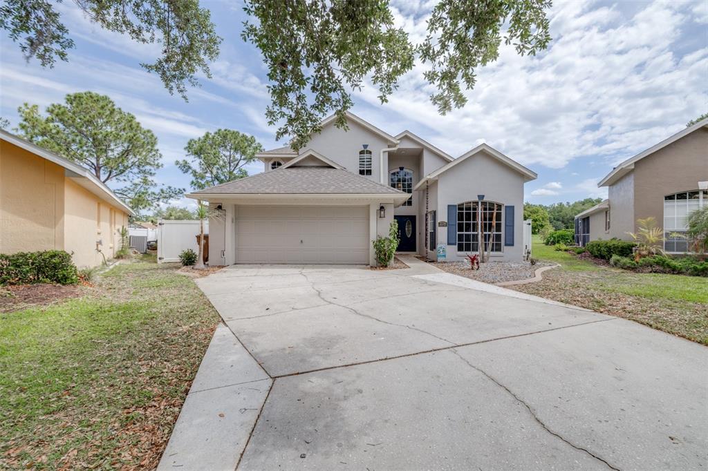 A two-story suburban house with a gray exterior, a two-car garage, and a concrete driveway — 2239 MALLORY CIRCLE, HAINES CITY, FL