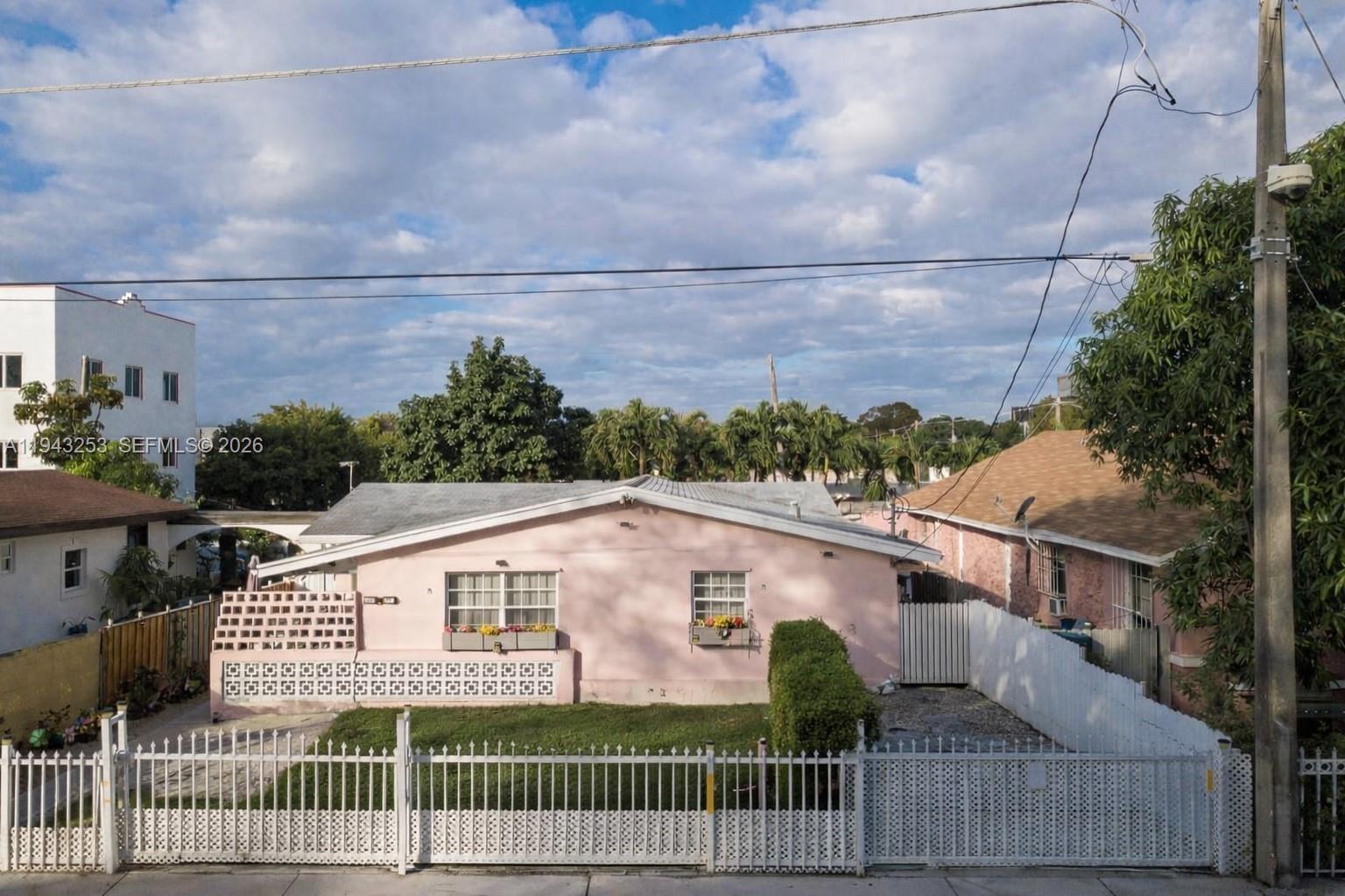 A pink single-story house with a white fence and a small front yard — 3240 NW 3rd Ave, Miami FL 33127, MIAMI, FL