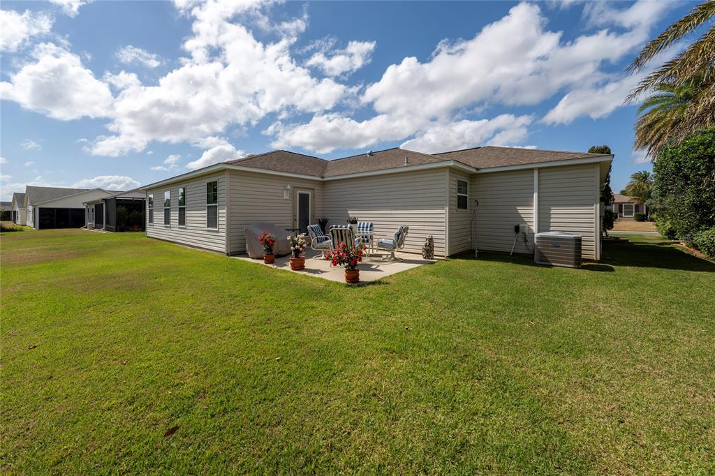 A spacious three-car garage with a polished speckled floor and two white paneled doors — 854 FENWICK LOOP, THE VILLAGES, FL