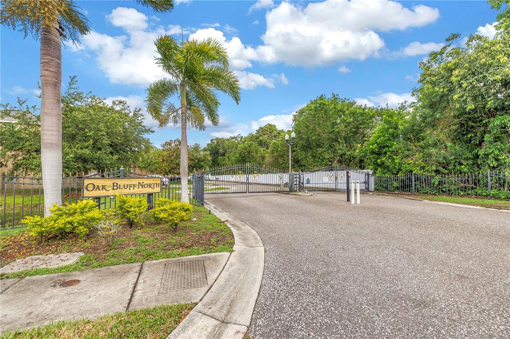 A gated entrance with a sign reading Oak Bluff North and palm trees — 6060 97TH AVENUE N, PINELLAS PARK, FL