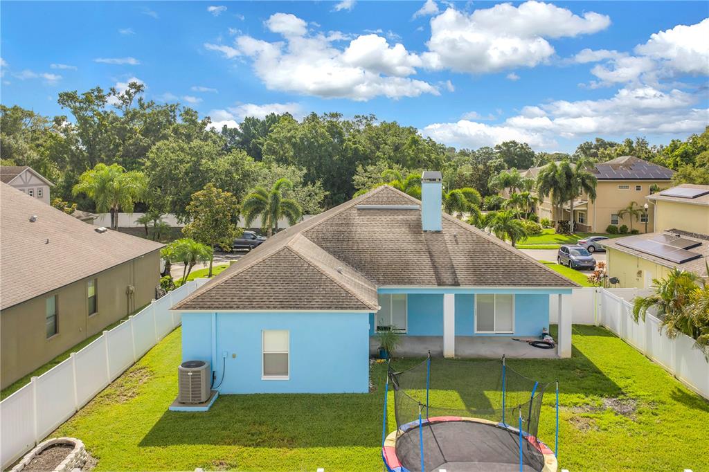 An aerial view of the backyard of a blue house with a trampoline and patio — 6060 97TH AVENUE N, PINELLAS PARK, FL