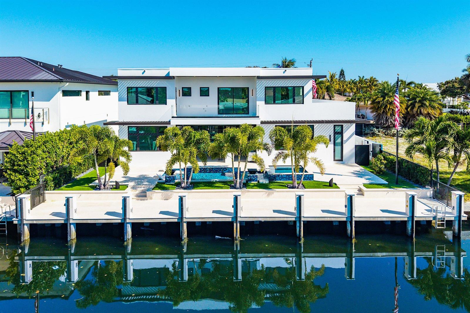 A modern white waterfront house features a swimming pool, palm trees, and a private dock — 2650 NE 48th Court, Lighthouse Point FL 33064, LIGHTHOUSE POINT, FL