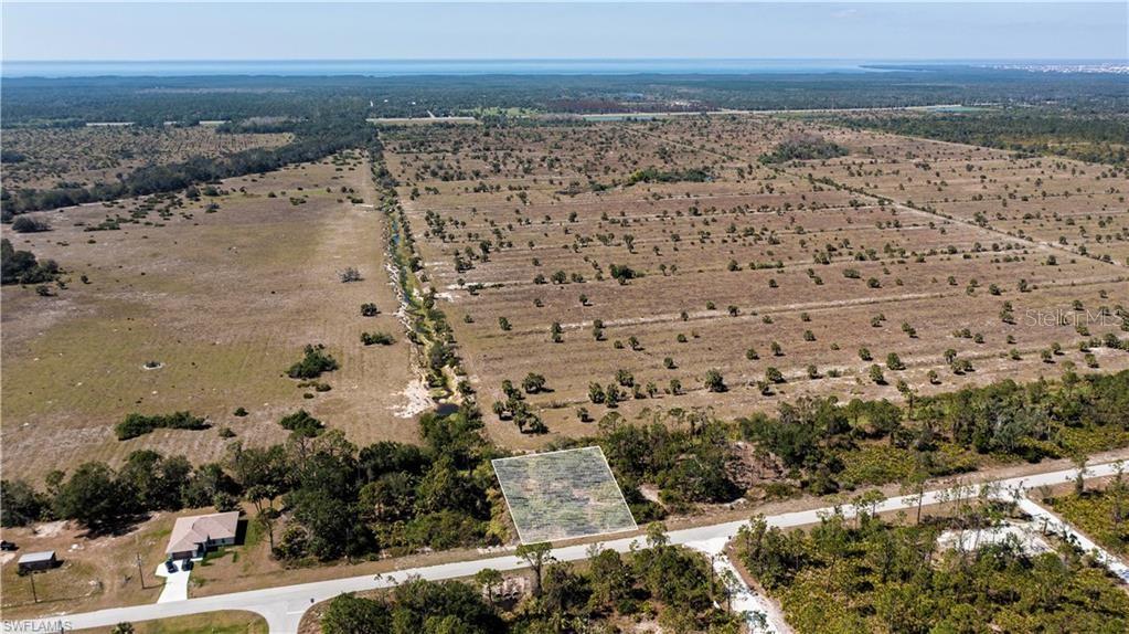 An aerial view shows a rectangular vacant lot outlined in white along a paved road — 12533 GREEN GULF BOULEVARD, PUNTA GORDA, FL