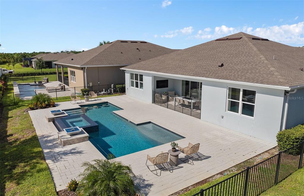 An aerial view of a backyard featuring a swimming pool, spa, and a paved patio — 6213 CITRUS GROVE COURT, ST CLOUD, FL