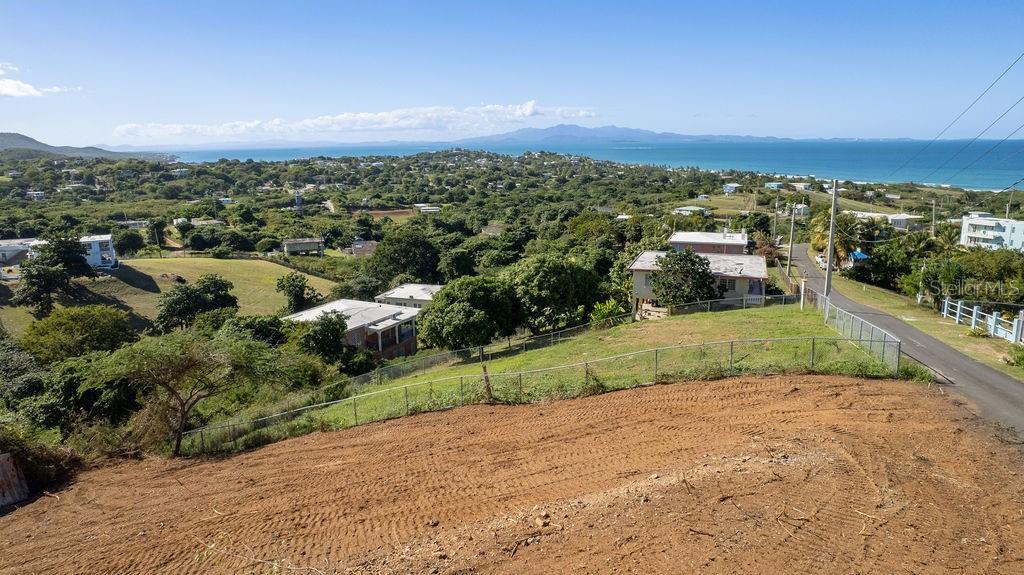 An elevated view of a sloped, cleared lot overlooking a coastal landscape and the ocean — 583 CALLE 16, VIEQUES, PR