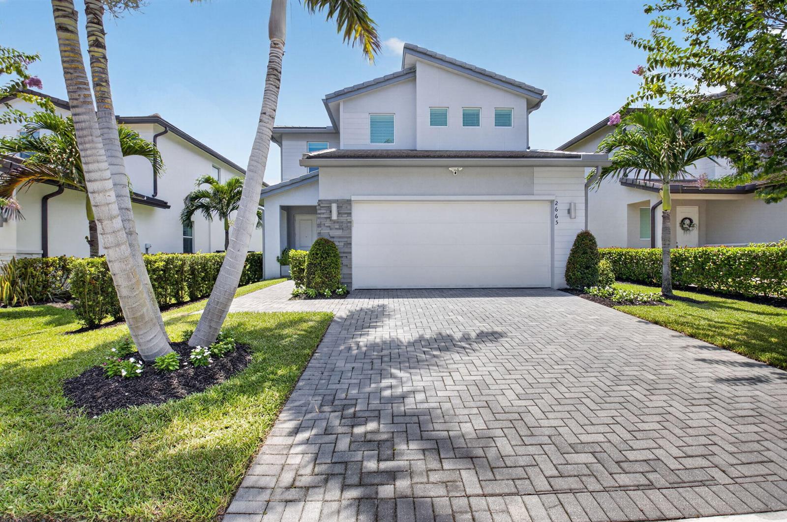 A two-story house with a white garage, stone accents, and a paved driveway — 2665 Country Lake Trail, Boynton Beach FL 33436, BOYNTON BEACH, FL