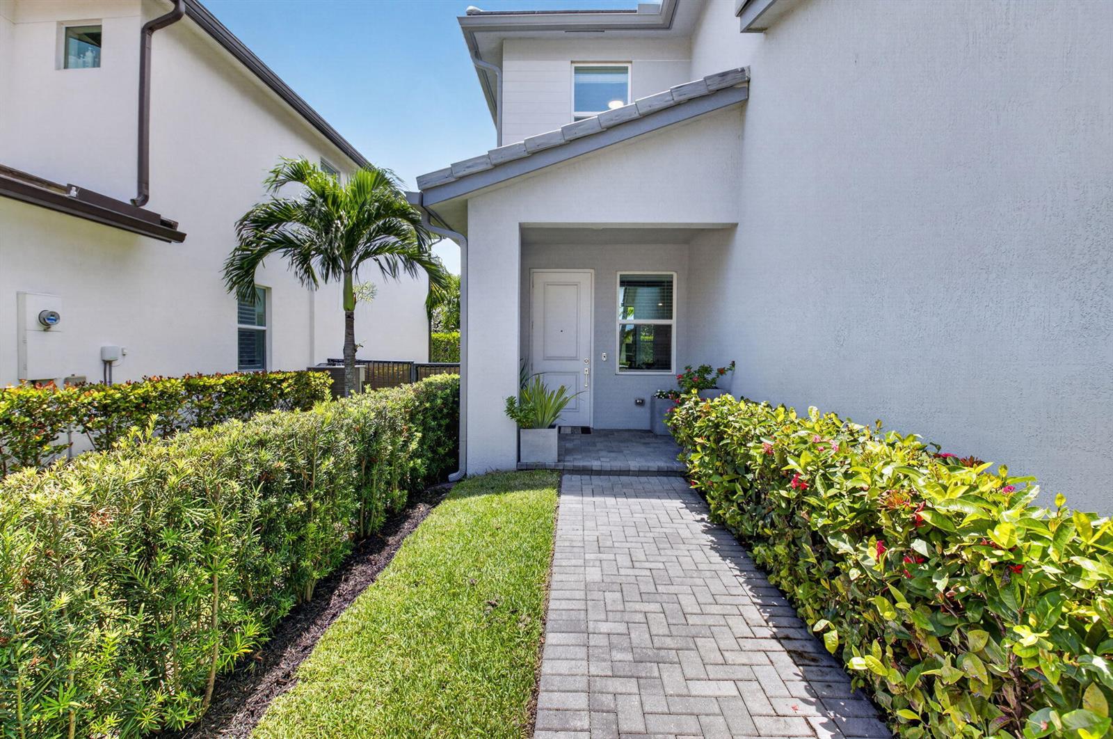 A paved walkway leads to the white front door of a two-story residential home — 2665 Country Lake Trail, Boynton Beach FL 33436, BOYNTON BEACH, FL