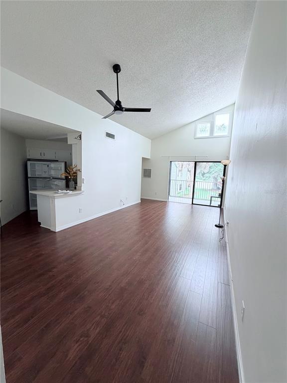 An open-concept living area features vaulted ceilings, dark wood flooring, and an adjacent kitchen — 3795 ATRIUM DRIVE UNIT U7, ORLANDO, FL