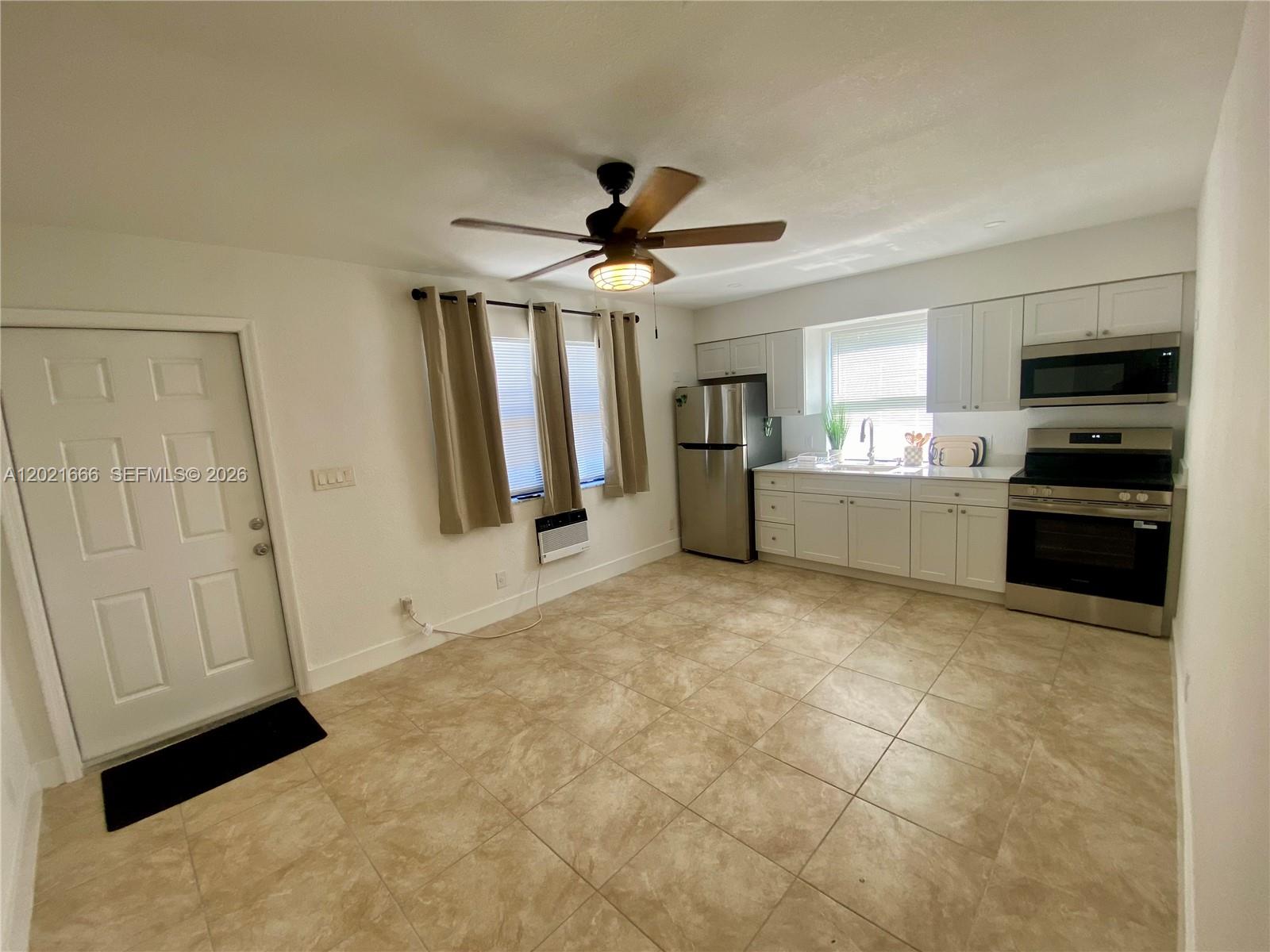 A kitchen with white cabinets, stainless steel appliances, and beige tile flooring — 1112 N 61st Ter # B, Hollywood FL 33024, HOLLYWOOD, FL