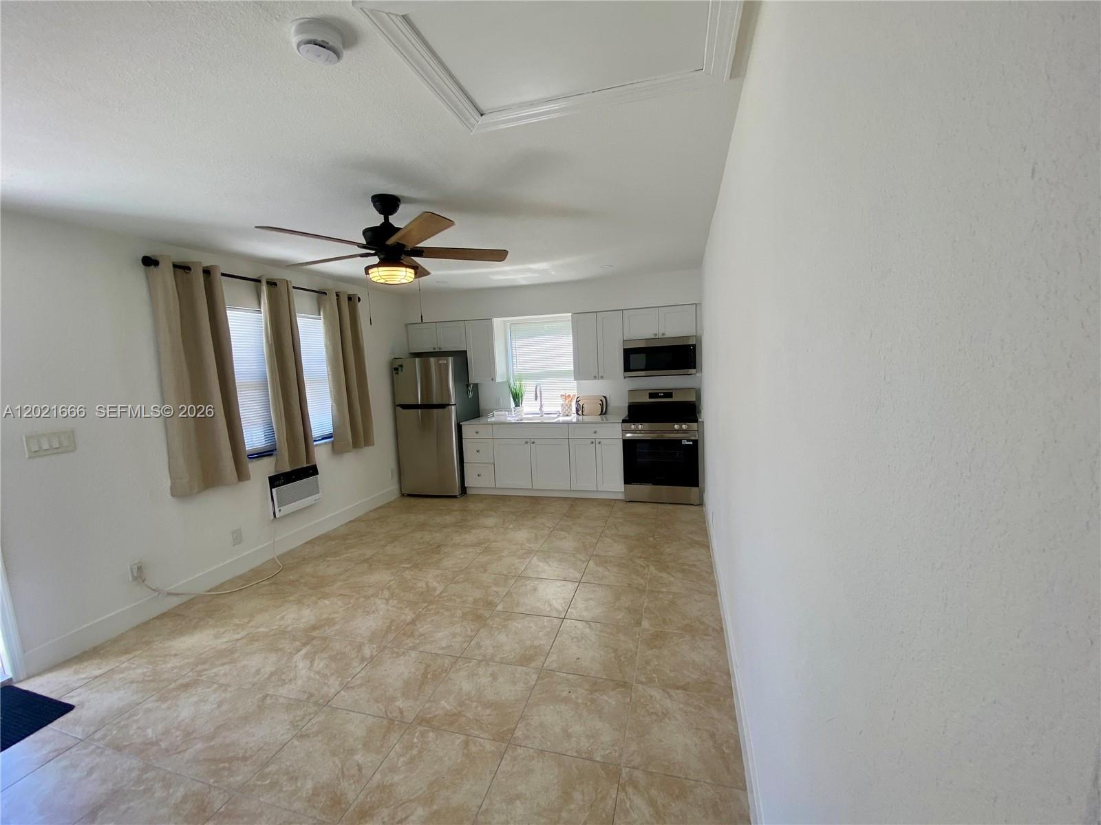 A kitchen with white cabinets, stainless steel appliances, and beige tile flooring — 1112 N 61st Ter # B, Hollywood FL 33024, HOLLYWOOD, FL