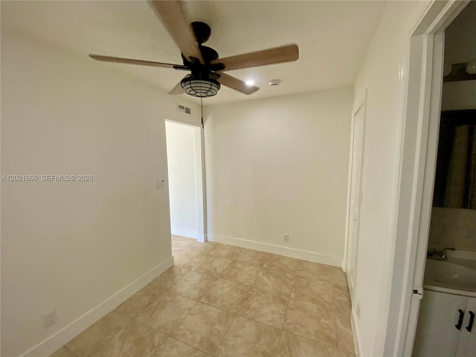 This room features tile flooring, a ceiling fan, and an adjacent bathroom doorway — 1112 N 61st Ter # B, Hollywood FL 33024, HOLLYWOOD, FL