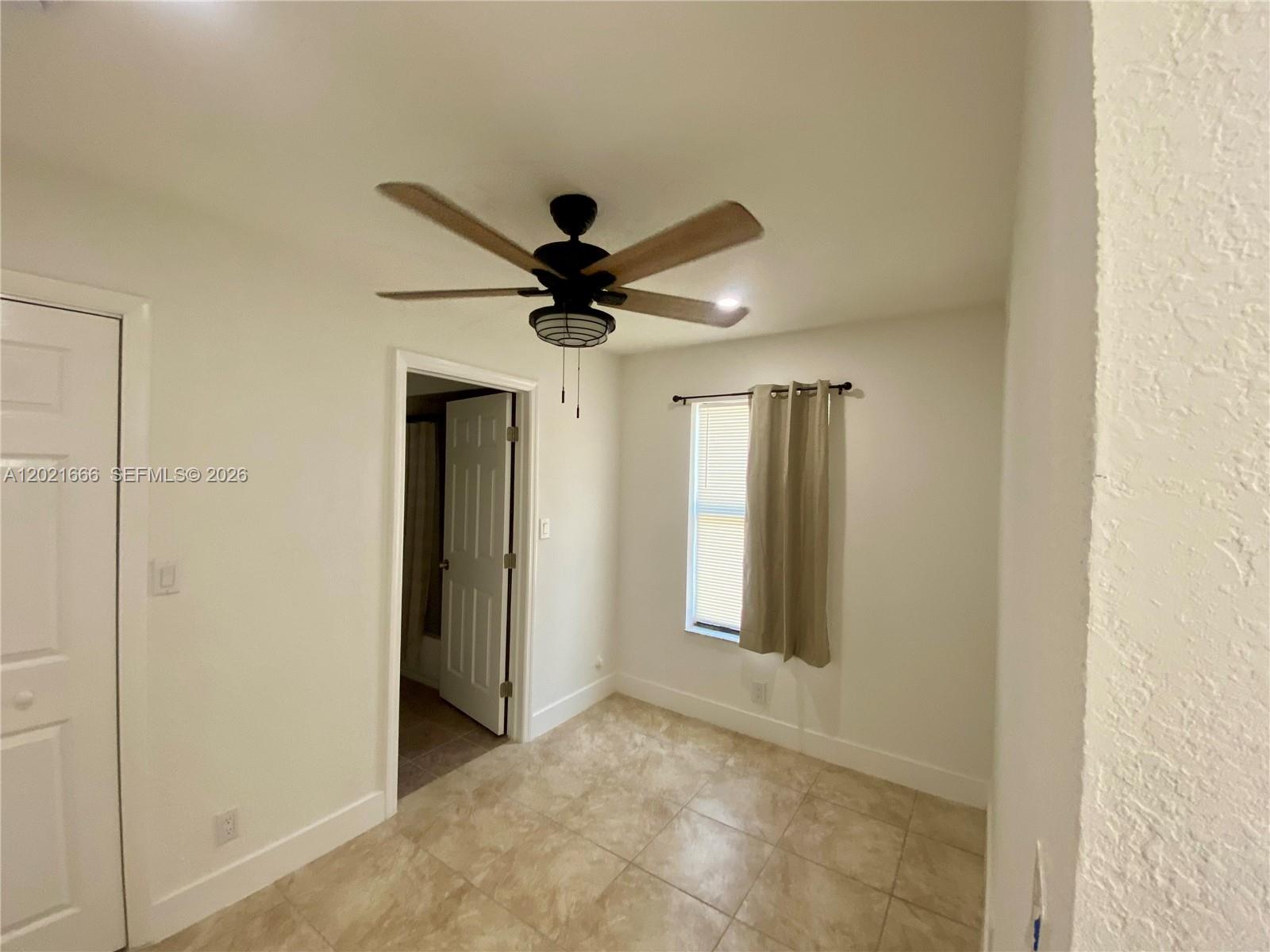 This room features tile flooring, a ceiling fan, and a window with curtains — 1112 N 61st Ter # B, Hollywood FL 33024, HOLLYWOOD, FL