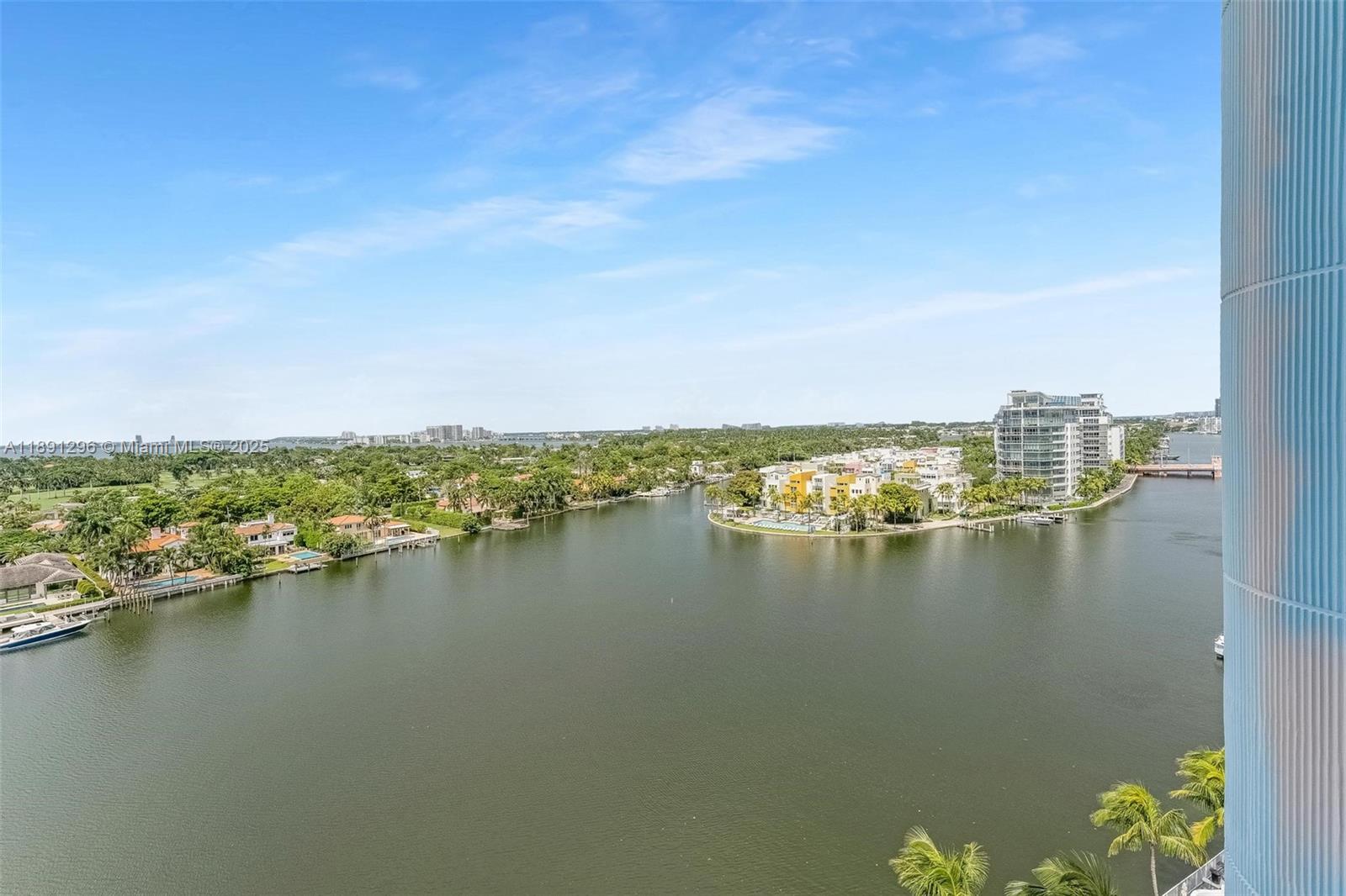 An elevated view shows a waterway surrounded by residential buildings and lush green trees — 5838 Collins Ave # 11B, Miami Beach FL 33140, MIAMI BEACH, FL