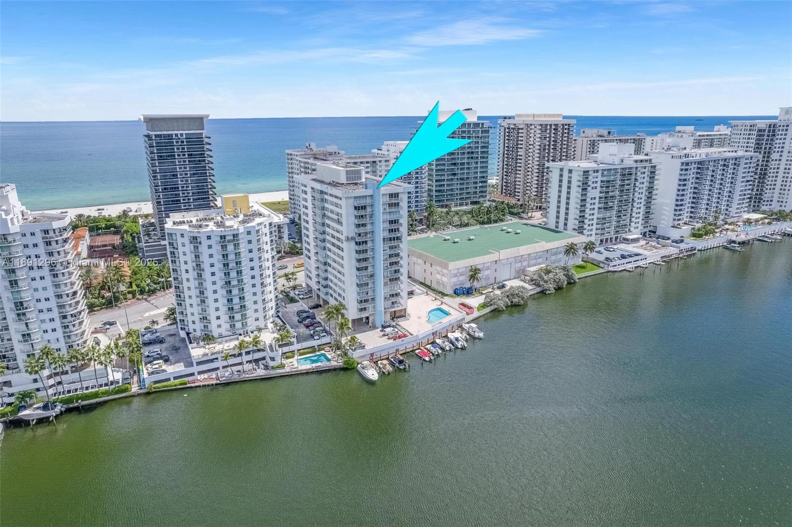 An aerial view shows several high-rise residential buildings situated along a waterfront with docked boats — 5838 Collins Ave # 11B, Miami Beach FL 33140, MIAMI BEACH, FL