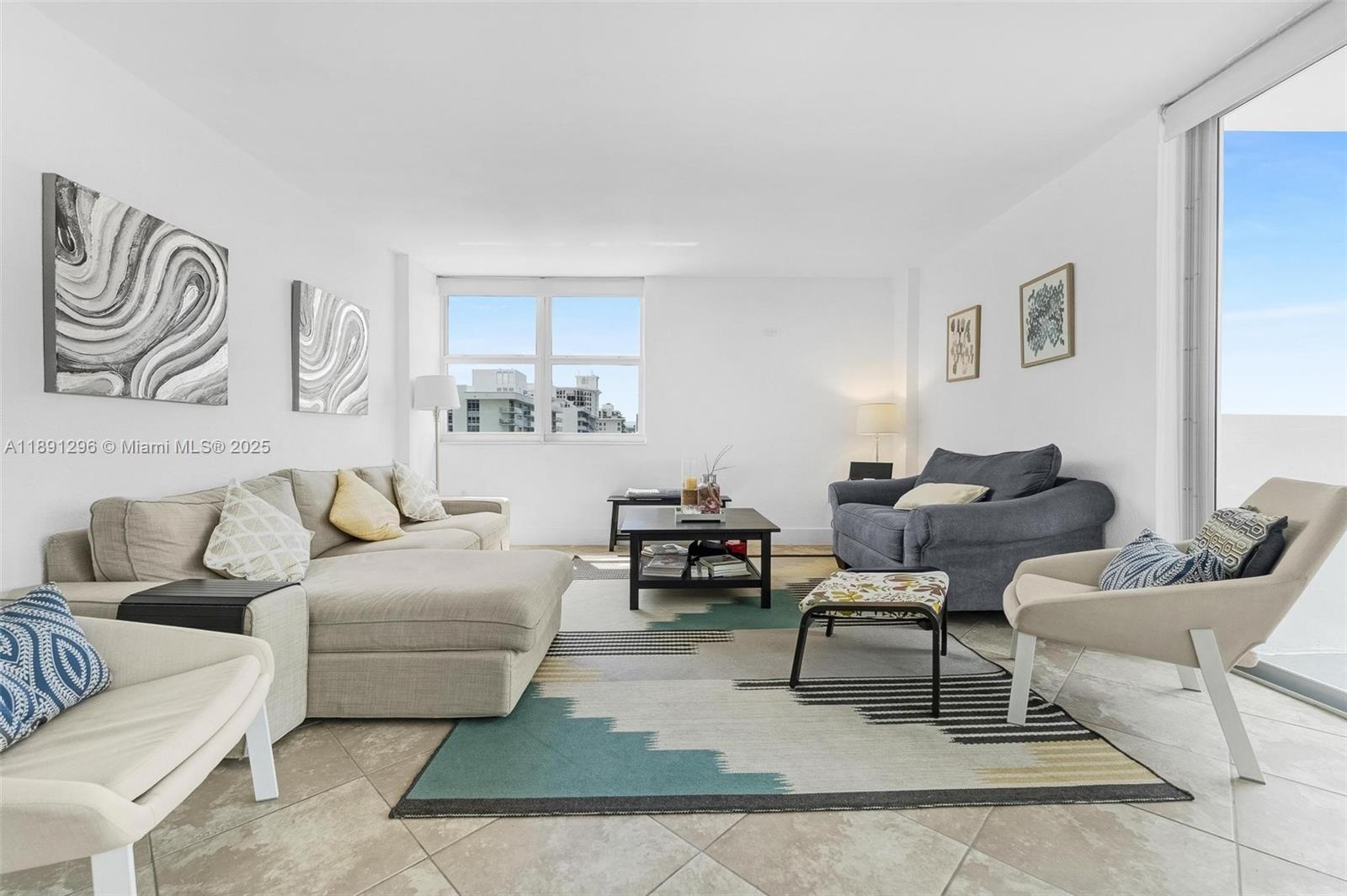 A living room features a sectional sofa, a dark armchair, and a patterned area rug — 5838 Collins Ave # 11B, Miami Beach FL 33140, MIAMI BEACH, FL