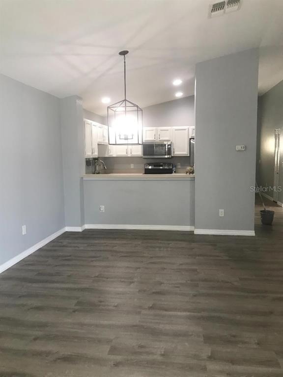 A view of a kitchen with white cabinets and a pendant light above a counter — 12377 NE 50TH VIEW, OXFORD, FL