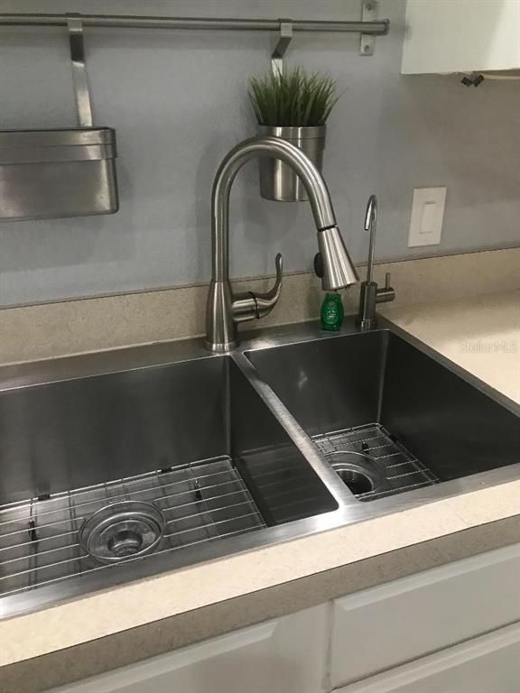 A stainless steel double-basin kitchen sink features a high-arc faucet and a small side sprayer — 12377 NE 50TH VIEW, OXFORD, FL