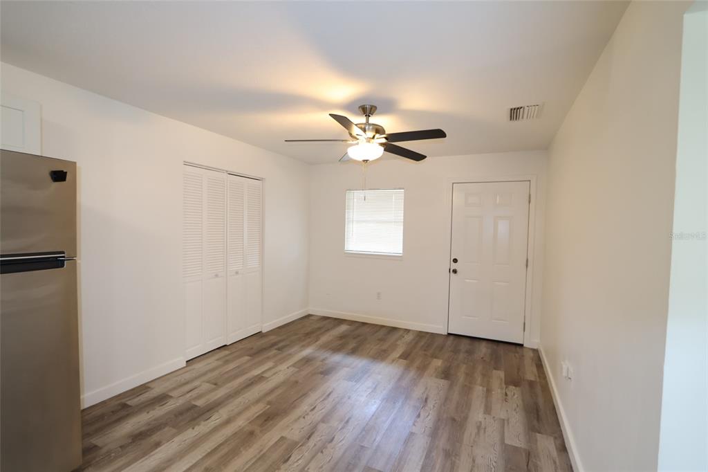 A room with wood-look flooring, a ceiling fan, a window, and a white door — 918 S SCENIC HIGHWAY, LAKE WALES, FL
