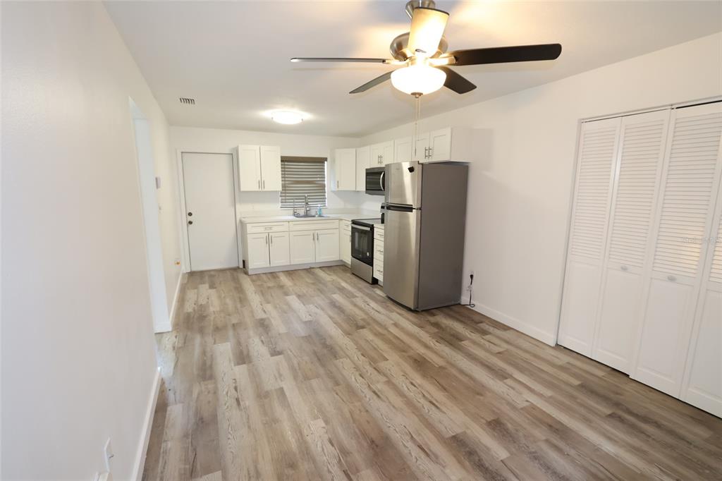 A kitchen with white cabinets, stainless steel appliances, and wood-look flooring — 918 S SCENIC HIGHWAY, LAKE WALES, FL