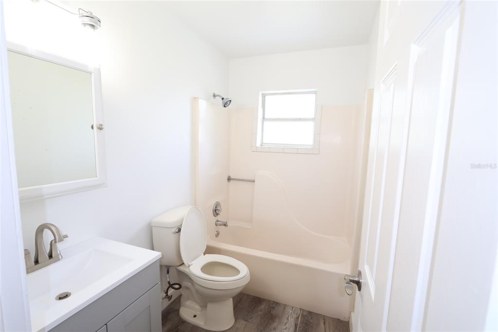A bathroom features a gray vanity, a white toilet, and a beige tub-shower combination — 918 S SCENIC HIGHWAY, LAKE WALES, FL
