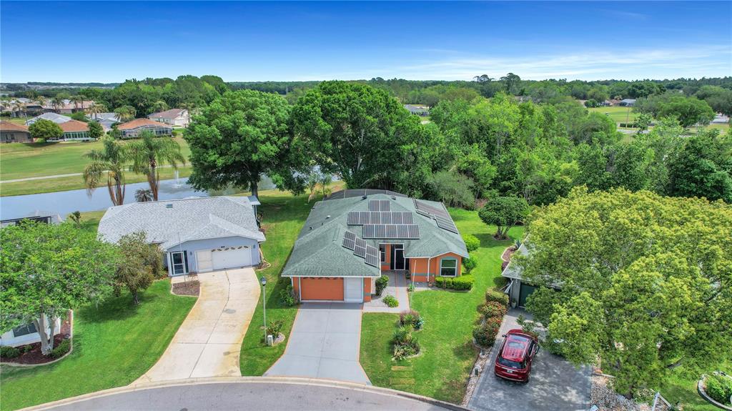 An aerial view of a suburban house with solar panels on a green roof — 333 RANCHWOOD DRIVE, LEESBURG, FL