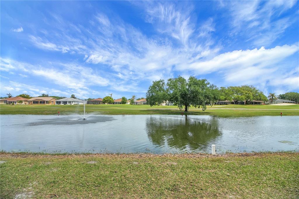 A pond with a fountain sits in front of a golf course and residential houses — 333 RANCHWOOD DRIVE, LEESBURG, FL
