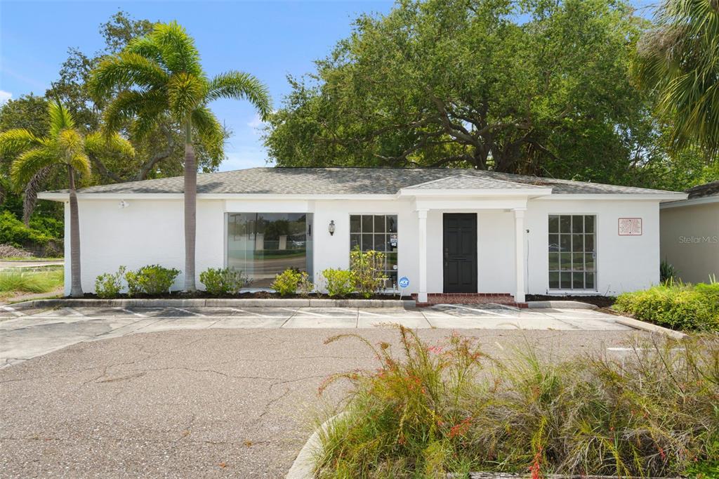 A single-story white building with a black front door and a paved parking lot — 1455 COURT STREET, CLEARWATER, FL