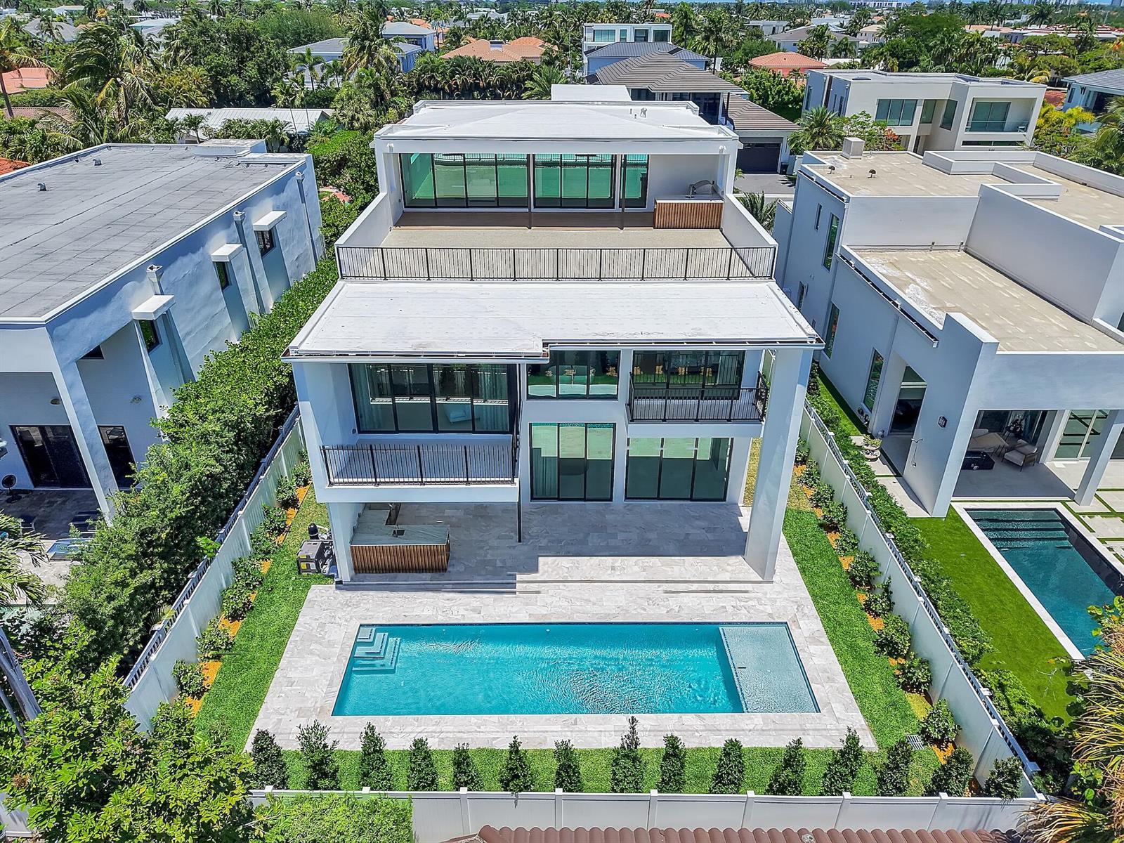 An aerial view of a modern three-story house with a swimming pool and backyard patio — 344 NE 2nd Street, Boca Raton FL 33432, BOCA RATON, FL