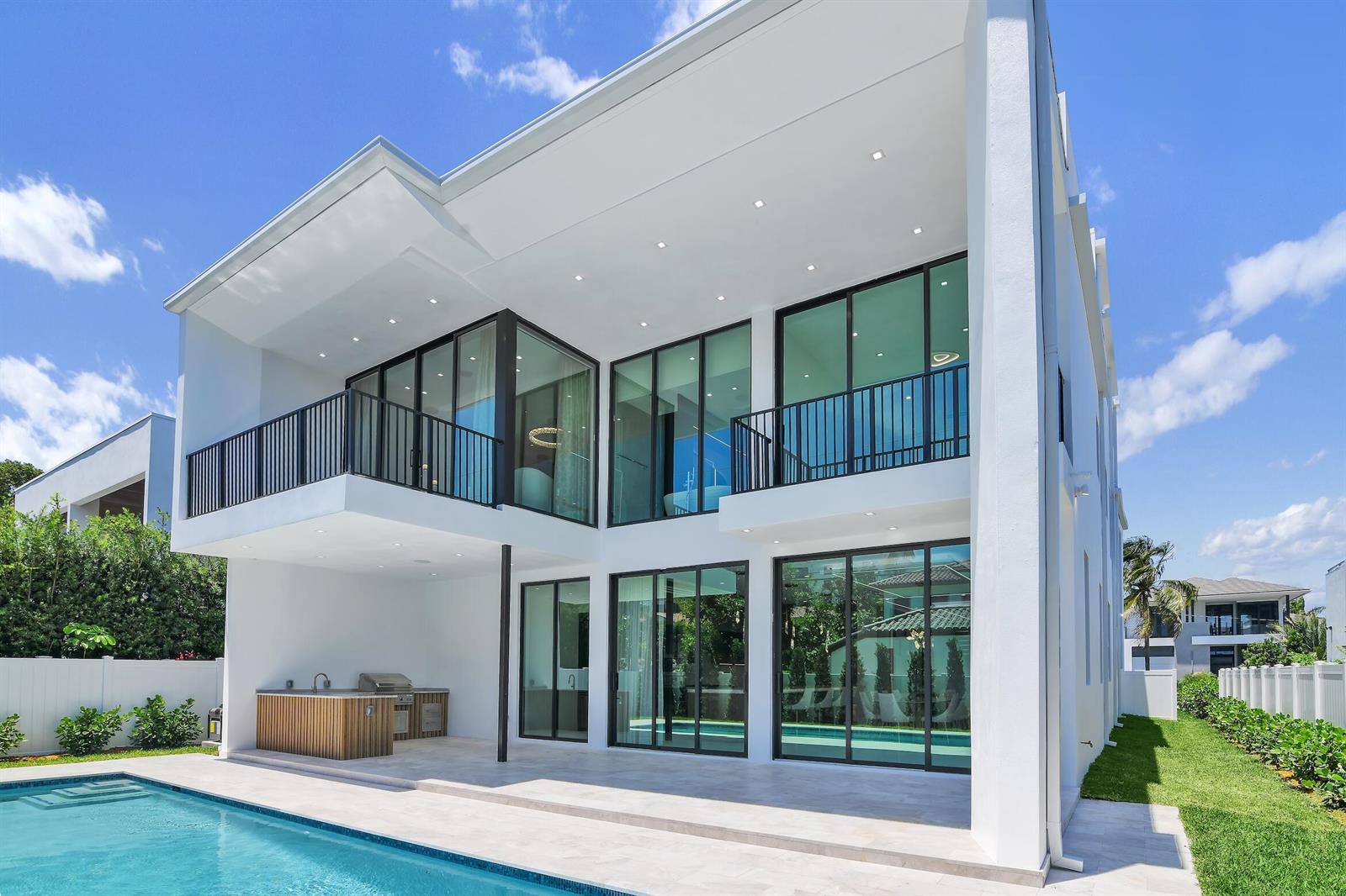 A modern white two-story house features a swimming pool, outdoor kitchen, and large glass doors — 344 NE 2nd Street, Boca Raton FL 33432, BOCA RATON, FL