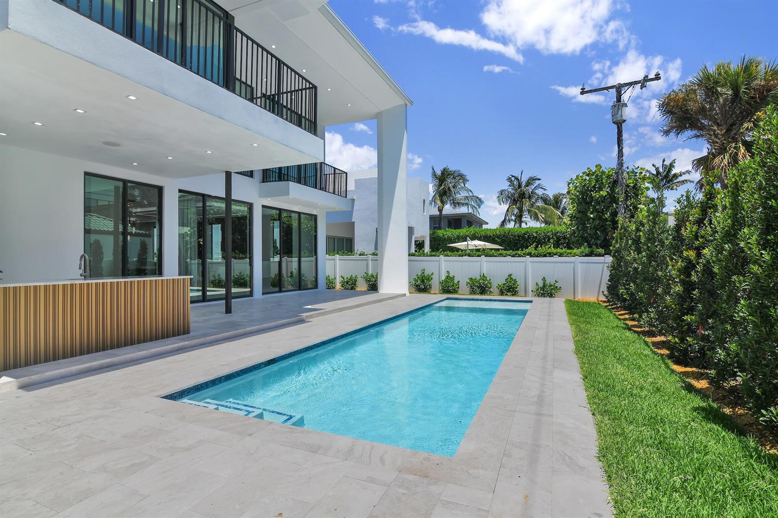 A modern two-story house features a rectangular swimming pool and a patio with a bar — 344 NE 2nd Street, Boca Raton FL 33432, BOCA RATON, FL