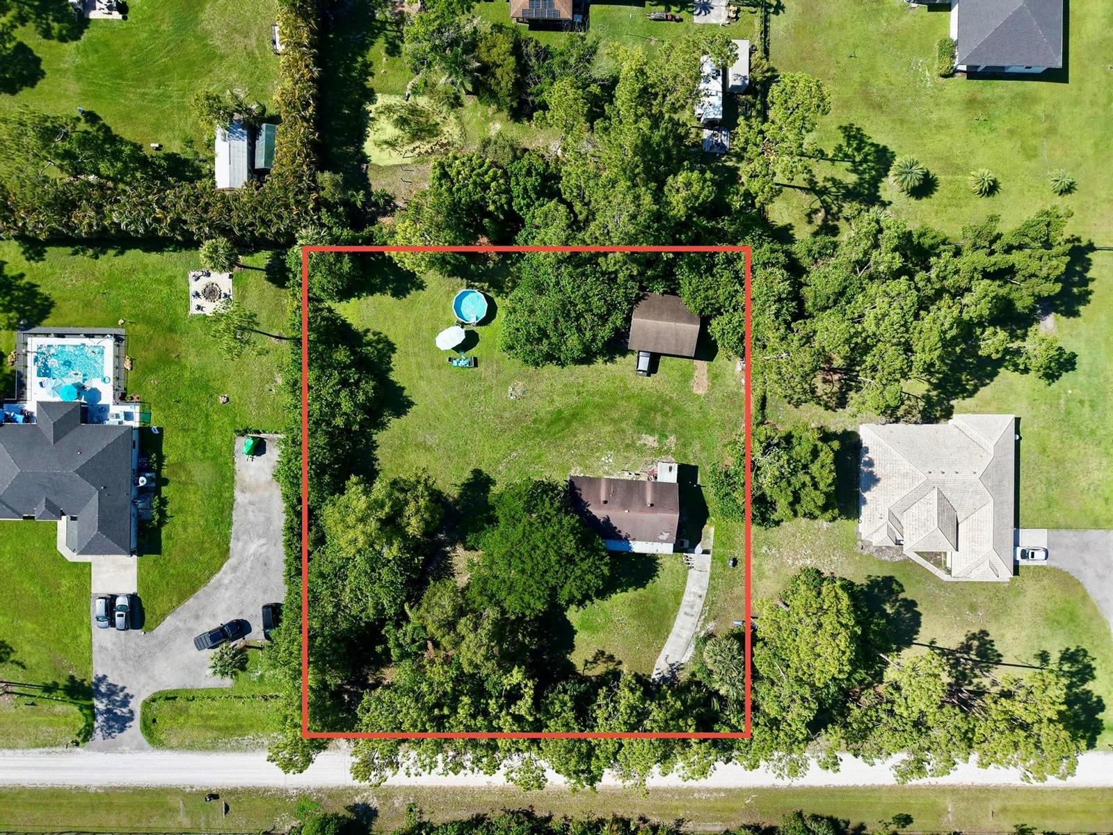 An aerial view shows a residential lot with a house, a detached garage, and a pool — 17605 92nd Lane N, FL 33470, FL