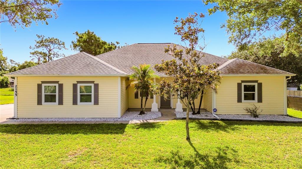 A single-story yellow house with a gray roof, white trim, and a front lawn — 2155 BARRATT COURT, ST CLOUD, FL