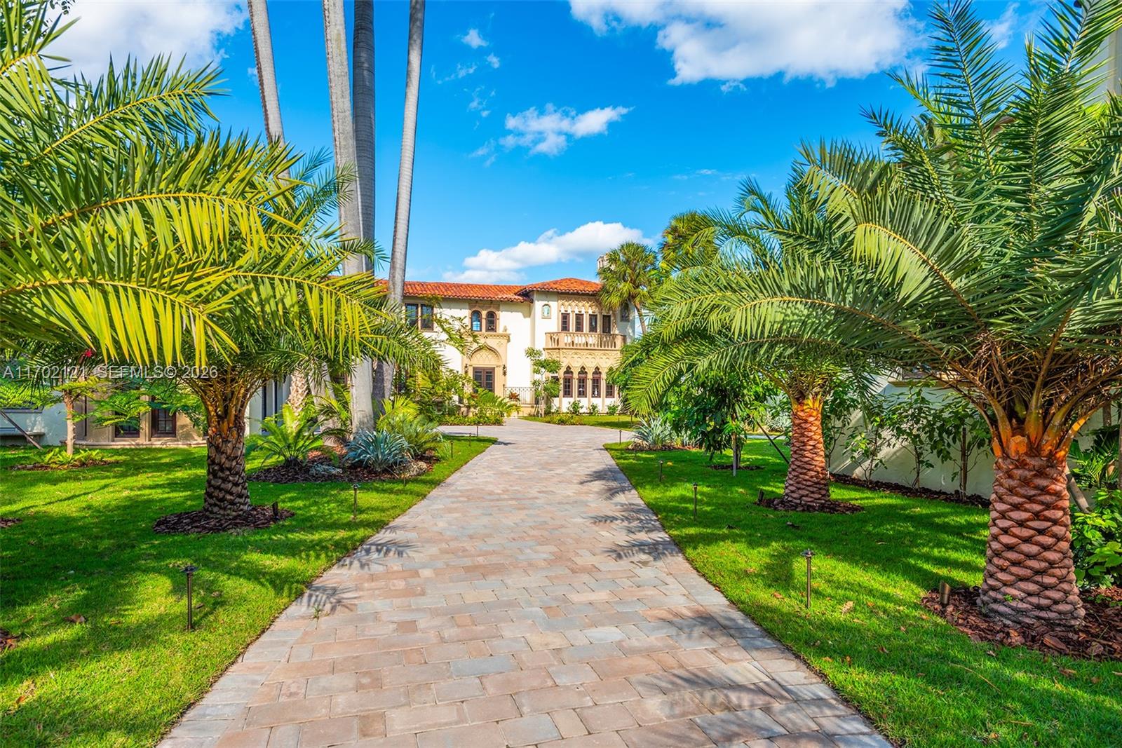 A paved driveway leads to a Mediterranean-style house framed by palm trees and green lawns — 49 Palm Ave, Miami Beach FL 33139, MIAMI BEACH, FL