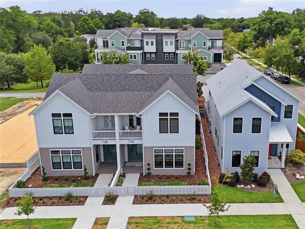 An aerial view shows a duplex with white and gray siding next to a blue house — 720 SW 131 STREET, NEWBERRY, FL
