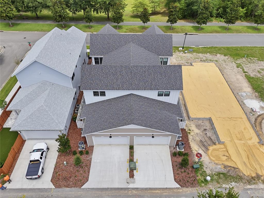 An aerial view shows a duplex with a two-car garage and an adjacent empty lot — 720 SW 131 STREET, NEWBERRY, FL