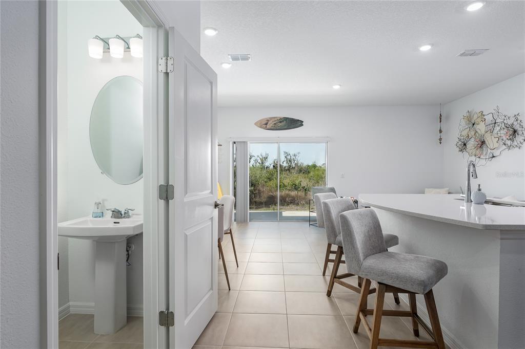 A view from a doorway looking into a kitchen with bar seating and sliding doors — 6011 WHETSTONE COURT, PALMETTO, FL