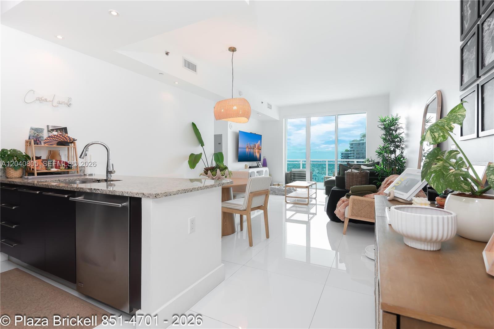 A modern open-concept kitchen and living area features white tile floors and balcony views — 950 Brickell Bay Dr # 4701, Miami FL 33131, MIAMI, FL