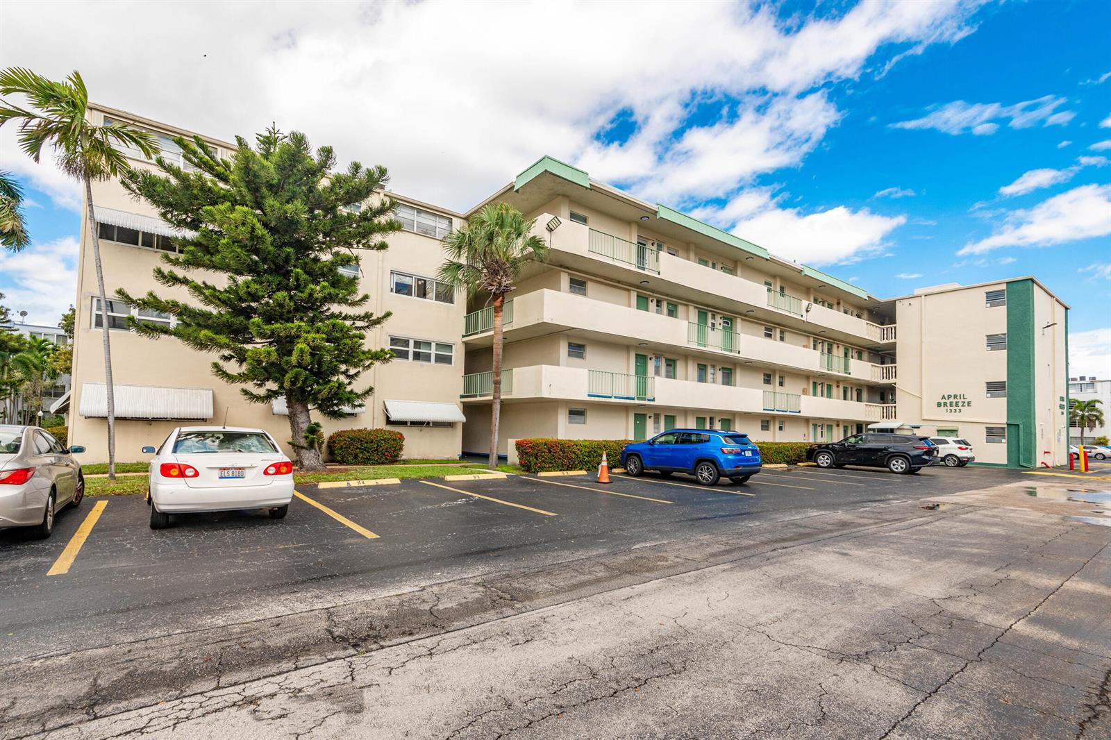 A multi-story apartment building with a parking lot and several parked cars in front — 1333 E Hallandale Beach Boulevard # 101, Hallandale Beach FL 33009, HALLANDALE BEACH, FL