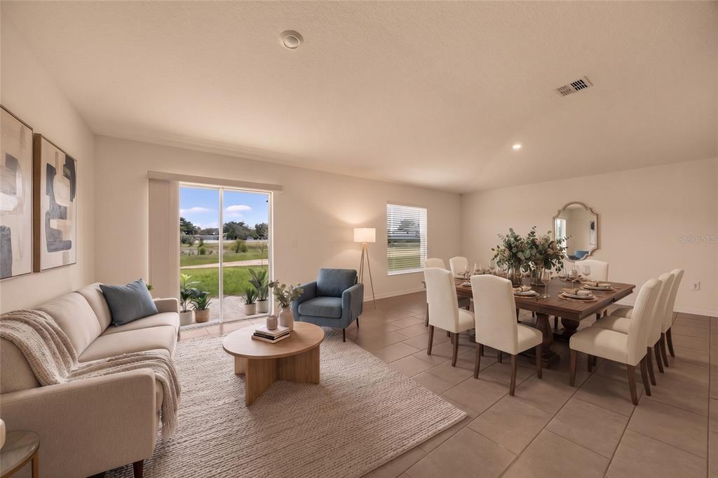 A living and dining room with tile floors, a sofa, a dining table, and sliding doors — 1119 JAMES PAUL ROAD, DAVENPORT, FL