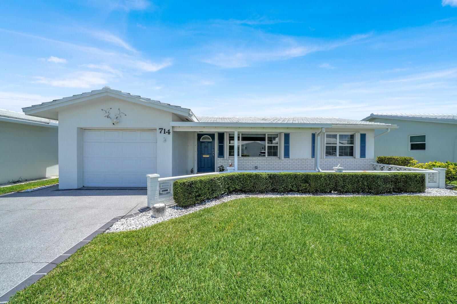A single-story house with a white exterior, a garage, and a manicured hedge in front — 714 SW 16th Street, Boynton Beach FL 33426, BOYNTON BEACH, FL