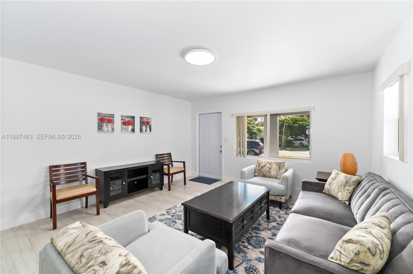 A living room features a grey sofa, two armchairs, a coffee table, and light flooring — 5731 SW 62nd Ter, Miami FL 33143, MIAMI, FL