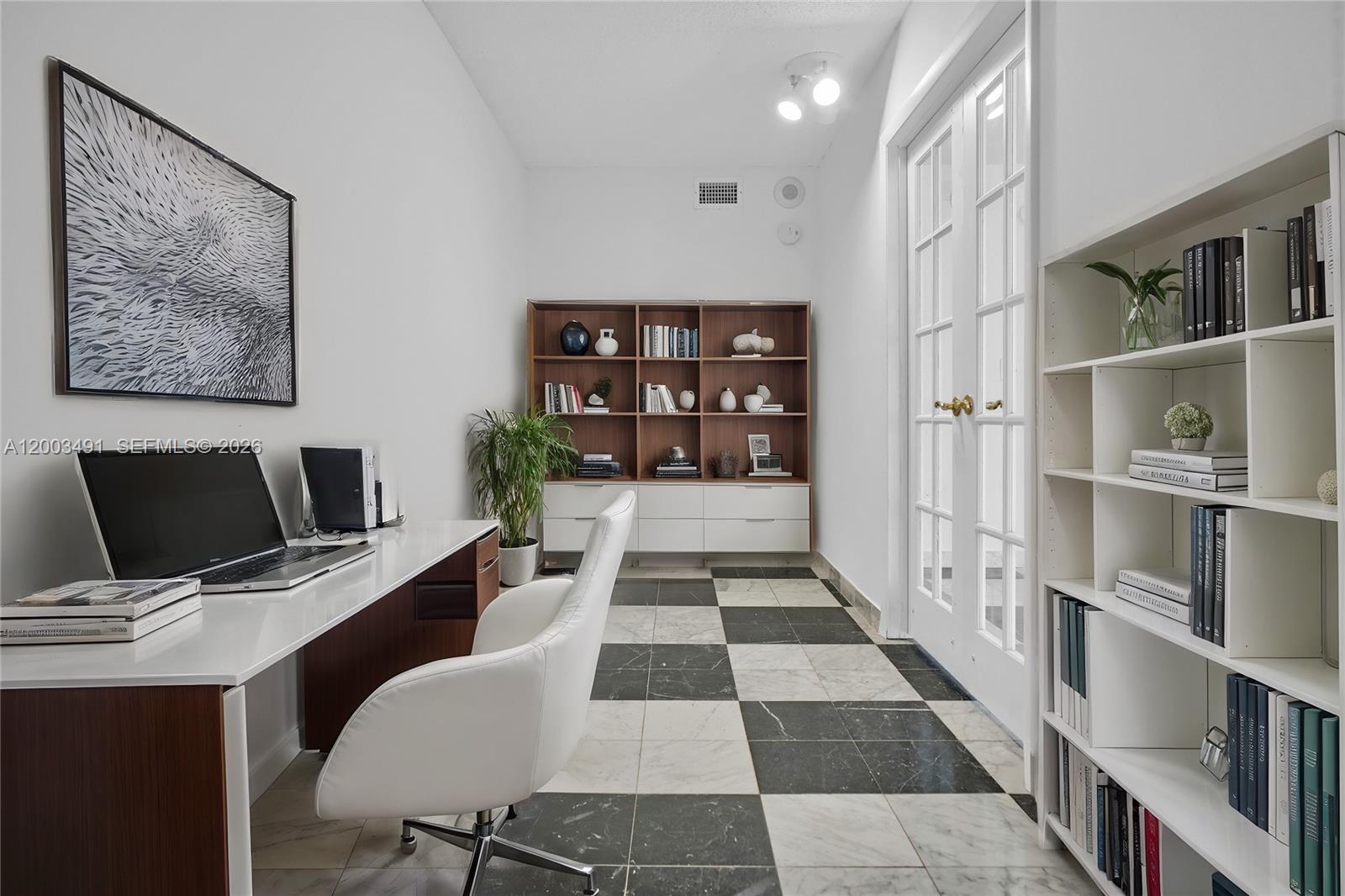 A home office features a white desk, a white chair, and black-and-white checkered tile flooring — 5555 Collins Ave # 3C, Miami Beach FL 33140, MIAMI BEACH, FL