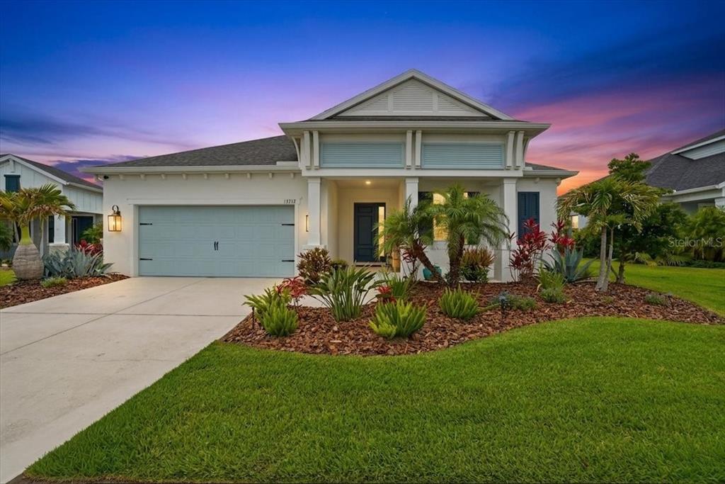 A single-story house with a light blue garage door and a covered front entryway — 13712 OLD CREEK COURT, PARRISH, FL