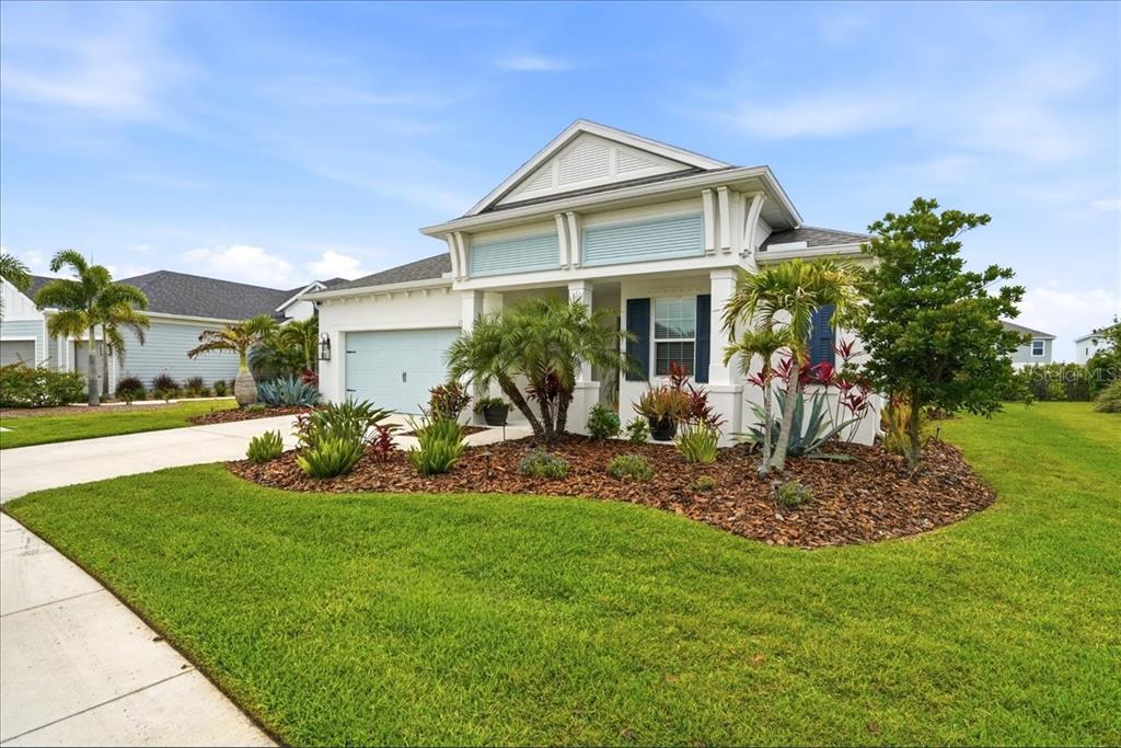 A single-story house with a light-colored exterior, a garage, and landscaped front yard — 13712 OLD CREEK COURT, PARRISH, FL