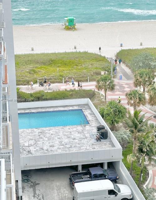 An elevated view shows a swimming pool deck, a parking area, and a beach — 401 Ocean Dr # 910, Miami Beach FL 33139, MIAMI BEACH, FL