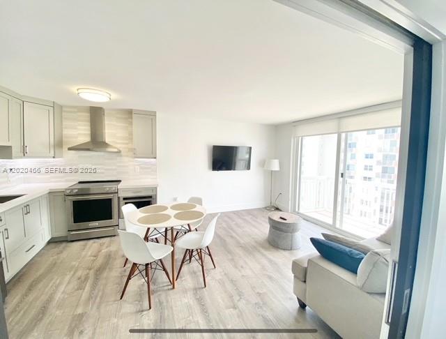 A modern open-concept kitchen and living area features light wood flooring and a dining set — 401 Ocean Dr # 910, Miami Beach FL 33139, MIAMI BEACH, FL